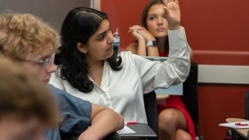 Student raising their hand to ask a question