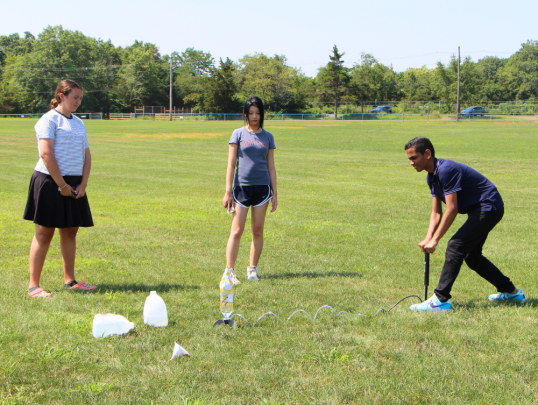 Students launching water bottle rockets outside