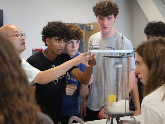 Students and instructor looking at engineering system