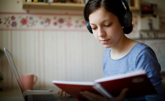 person wearing headphones and looking at a notebook